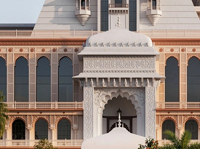 Ornate carvings on a white pavilion before the temple facade